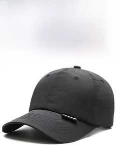 Detail of a black quick-dry baseball cap featuring a stiff brim and minimalist fabric label