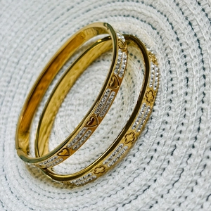 Golden titanium steel bracelets with clover and heart motifs and sparkling pavé crystals