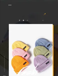 Close-up of colorful knitted beanies with letter patches in six vibrant colors