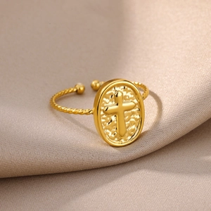 Macro detail of 18k gold plated stainless steel ring with embossed cross and twisted band