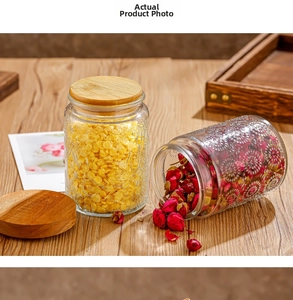 Detail of embossed glass jars with bamboo lids storing cereal and dried flowers