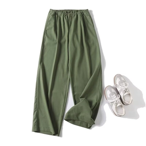 Army green wide-leg trousers with elastic waist paired with white sneakers on white background