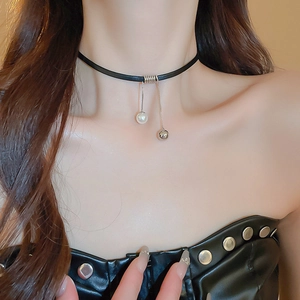 Close-up of minimalist black choker with pearl and silver metal ball pendant charms