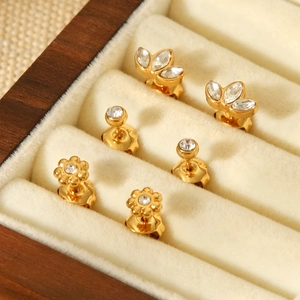 Close-up of three pairs of gold stainless steel stud earrings with zircon in a velvet box