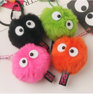 Macro detail of fluffy plush soot sprite keychains in bright green, black, pink and orange