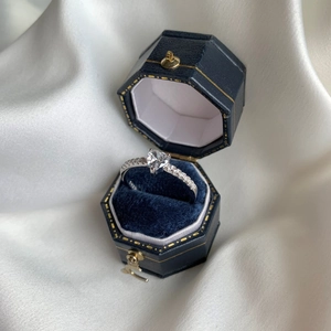 Detail of S925 sterling silver stamp on heart-shaped ring in blue velvet jewelry box