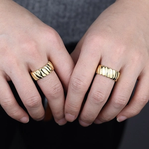 Detail of gold textured croissant rings with ribbed surface worn on fingers