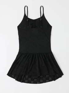 Detail view of black eyelet embroidery fabric and ruffled hem on the one-piece swimsuit