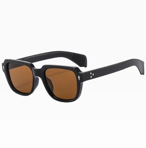 Detail view of square frame sunglasses with black frame, brown lenses and silver metal hinges