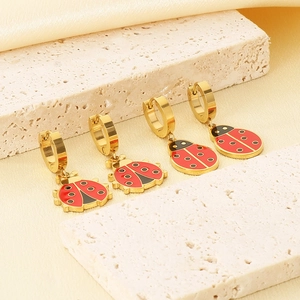 Macro view of gold-plated stainless steel ladybug earrings with red enamel detail