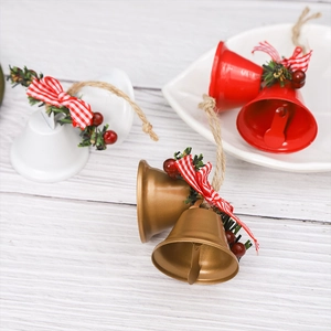 Close-up of red, white and gold Christmas bells with pine needles and plaid bows