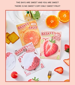 Detail of realistic fruit shaped memo pads featuring strawberry and orange designs