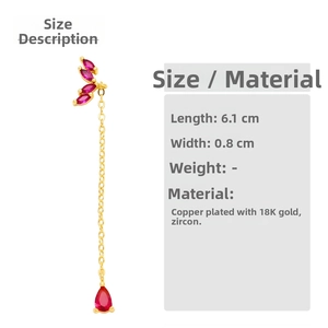 Detail view of 18K gold plated tassel earrings with red zircons measuring 6.1cm by 0.8cm