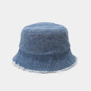 Détail des bords effilochés sur un bob en jean bleu avec une finition délavée vintage