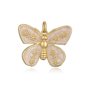 Detailed close-up of a golden butterfly pendant with pink enamel and delicate floral patterns