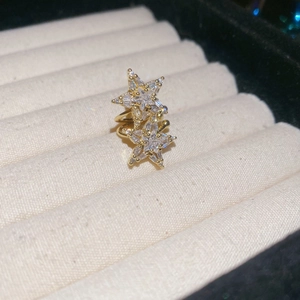 Macro shot of gold double star ear cuff with sparkling zircon inlay on velvet