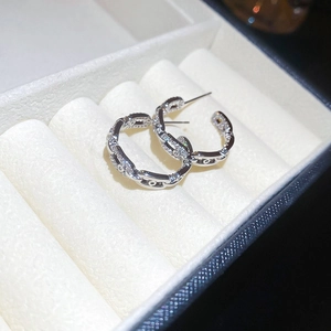Macro shot of interlocking chain link C-hoop earrings with paved clear cubic zirconia