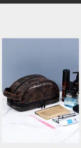 Dettaglio macro del beauty case in pelle marrone con doppia zip e ampia capacità