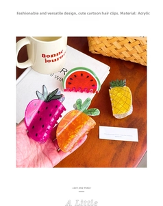 Detail of cute acrylic fruit hair claws featuring strawberry and pineapple designs