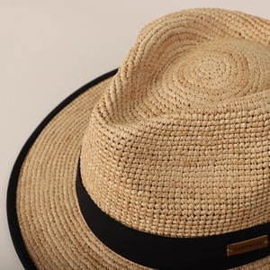 Classic straw boater hat with black ribbon and handmade tag for summer sun protection