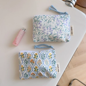 Detail of floral cotton pouches with woven zipper pulls and simple wish branding