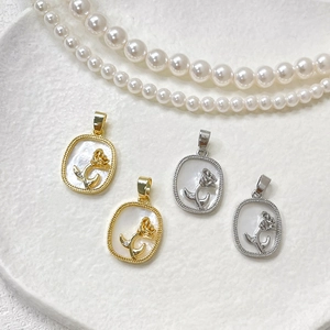 Macro detail of 14k gold and silver rectangle charms with mother of pearl rose inlay
