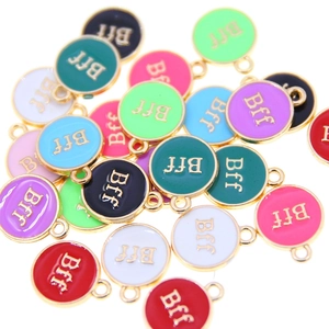 Flat lay of colorful round enamel BFF charms for DIY jewelry making in multiple colors