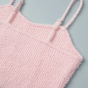 Close-up of pink fuzzy knit top with adjustable straps and ribbed plush texture