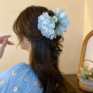 Detailed back view of a light blue handmade fabric lotus hair claw clip on a woman's hair