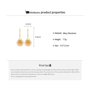 Detail view of gold-tone floral drop earrings with rhinestones and hollow mesh design