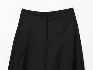 Détail du pantalon noir à taille haute montrant la texture sergé et les coutures nettes
