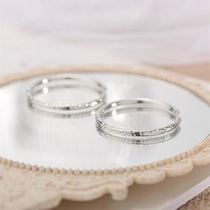 Detailed close-up of silver textured hoop earrings on a vintage mirror background