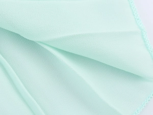 Detailed macro view showing breathable texture and fine edging of mint green chiffon fabric