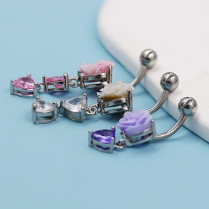 Détails de piercings de nombril avec fleurs en résine et zircons en forme de cœur