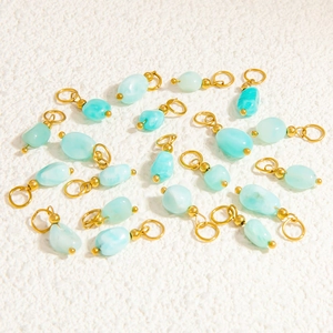 Detailed view of light blue natural stone pendants with gold ring hardware for DIY jewelry