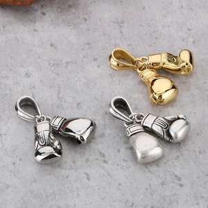 Detailed macro view of retro stainless steel boxing glove pendants in gold and silver