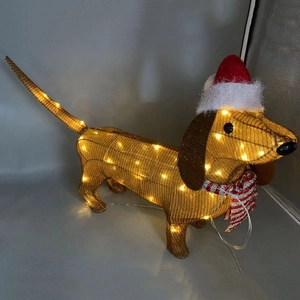 Detail of a lighted golden Dachshund figure wearing a festive red Santa hat and scarf