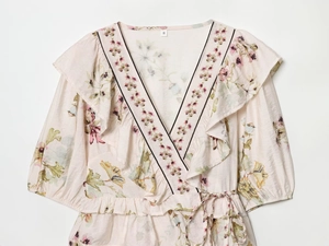 Detail view of pink floral pattern on linen blend top with delicate ruffle and V-neckline
