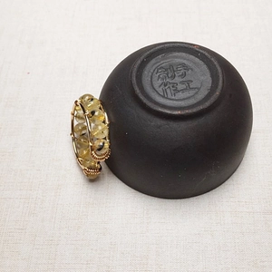 Detail of handcrafted gold-wrapped wire ring featuring double-row rutilated quartz beads