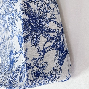 Detail shot showing the precise stitching and blue Toile de Jouy pattern on the canvas bag