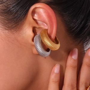 Gold and silver C-shaped ear cuffs with fish scale texture on fashion model's ear