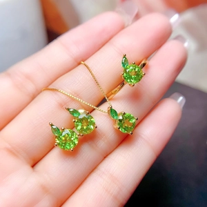 Exquisite gold jewelry set with green circular gemstones and apple shaped pendant necklace