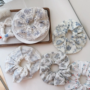 Set of five floral cotton scrunchies with assorted prints on a wooden tray decor