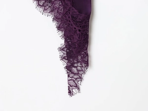 Gros plan détaillé du tissu en dentelle violet foncé montrant des motifs floraux complexes