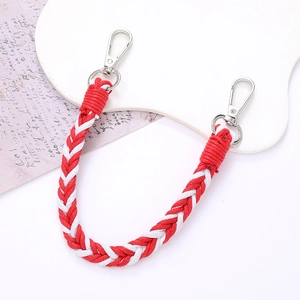 Detail of red and white hand-woven strap with silver metal buckles on white background