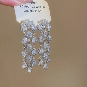 Macro detail of sparkly S925 silver fringe earrings with hollow floral zircon stones