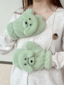 Nahaufnahme weicher grüner Teddy-Plüschfäustlinge mit Bär-Design und praktischem Umhängeband