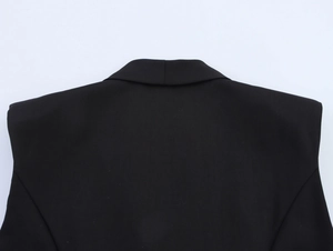 Close-up of the back shoulder cut and smooth fabric texture of a black blazer jacket