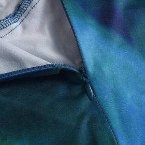 Détail macro du tissu imprimé dégradé bleu-vert avec fermeture éclair invisible soignée
