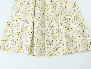 Close-up of yellow floral print on cream poplin fabric showing midi dress texture